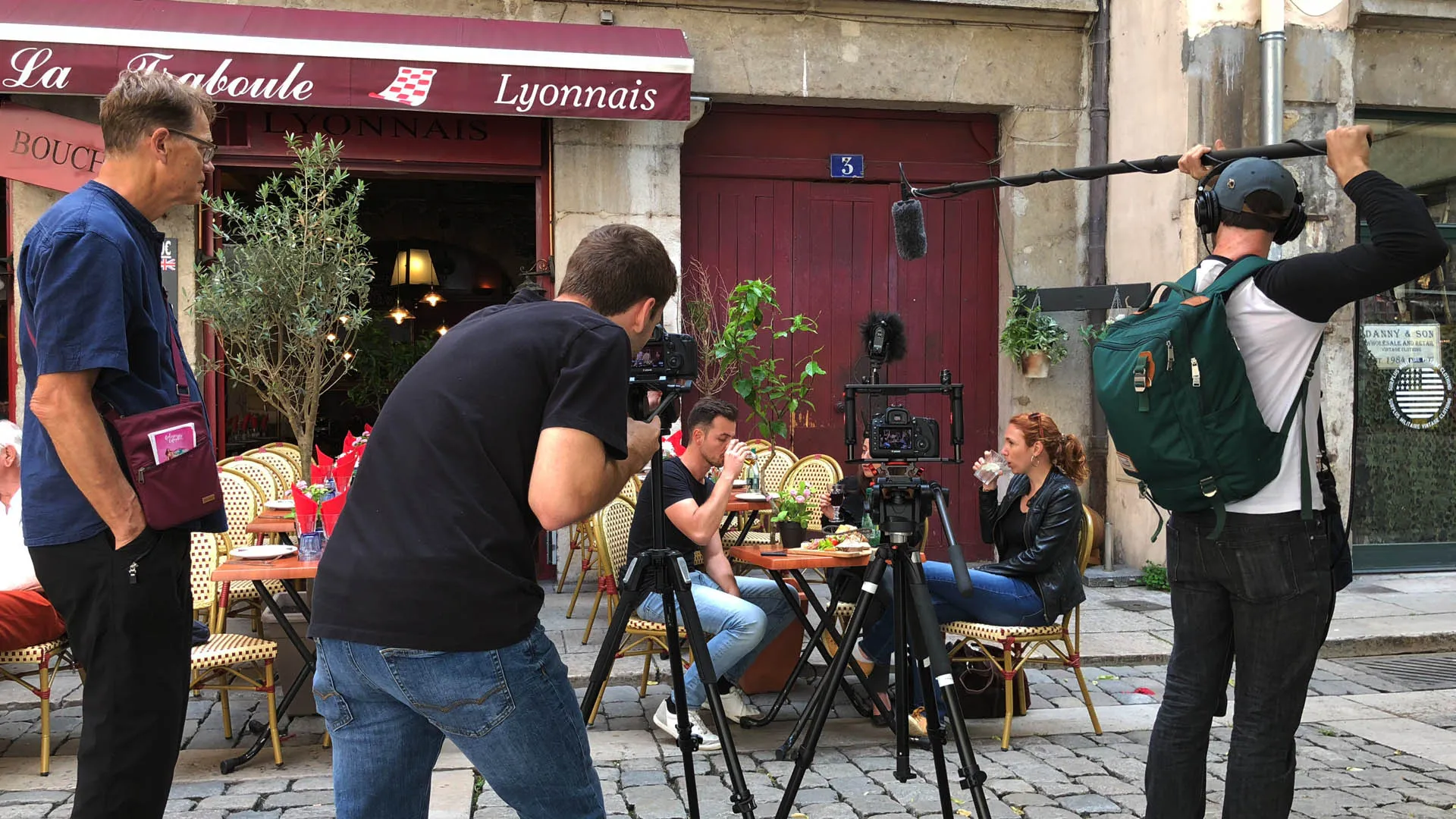 A production crew films outside a French restaurant