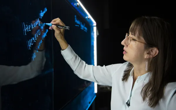 A professors stands in front of a light board.